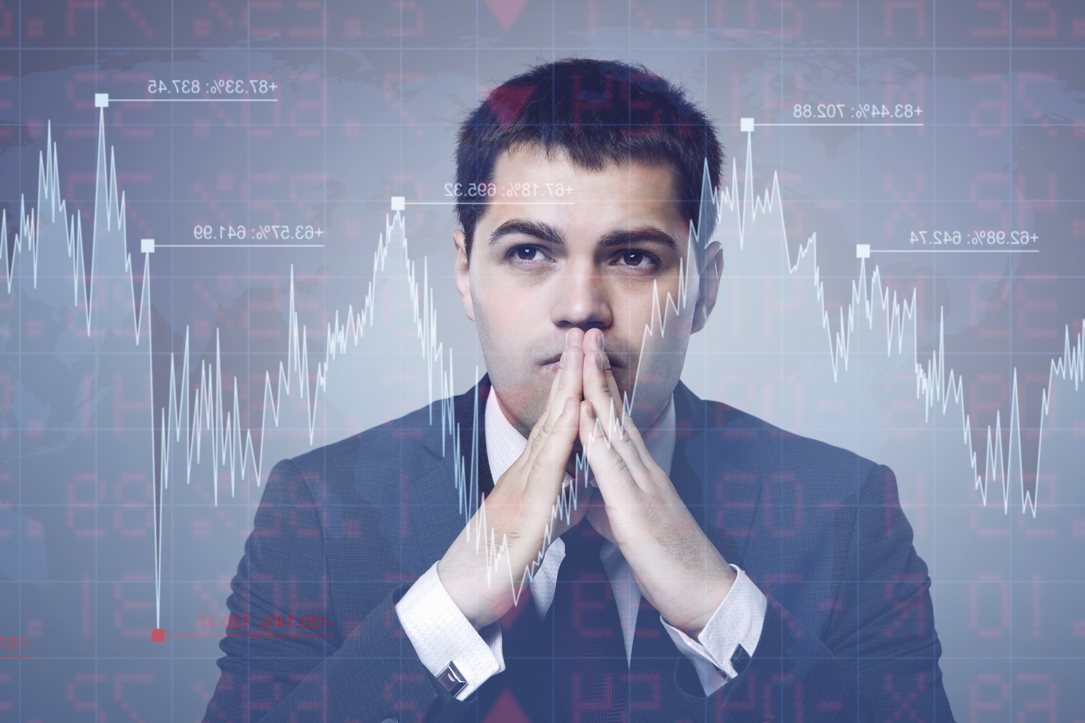 Investor with hands in front of face and stock market chart superimposed