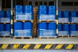 Large blue metal barrels stacked together in a factory.jpg