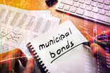 A person writing Municipal Bonds in a notebook
