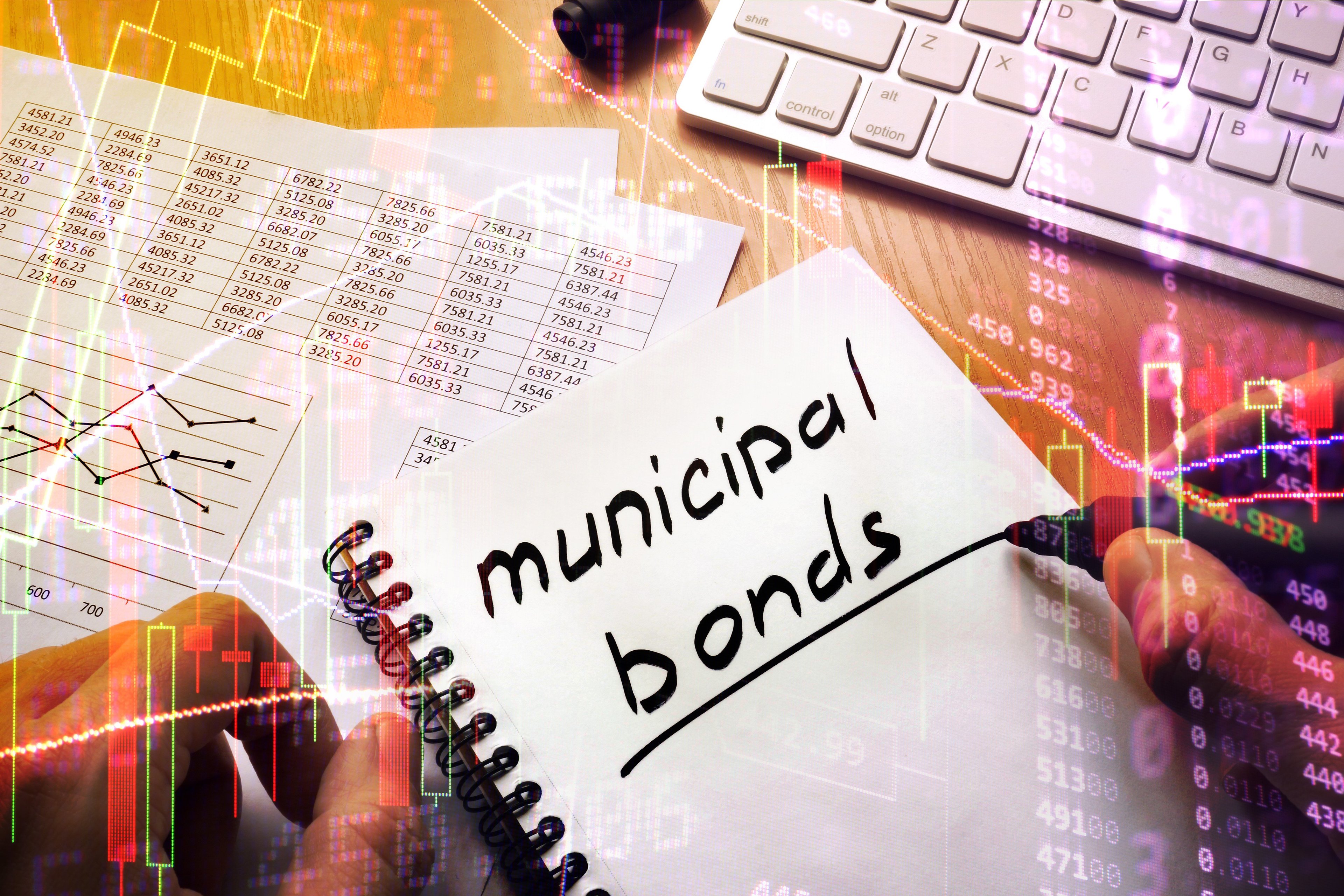 A person writing Municipal Bonds in a notebook.