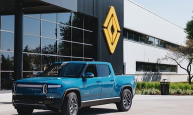 Rivian truck in front of building with Rivian logo.