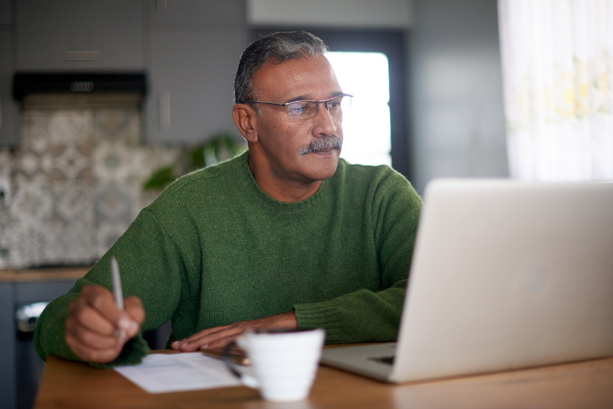 Retired person reviewing finances on laptop.