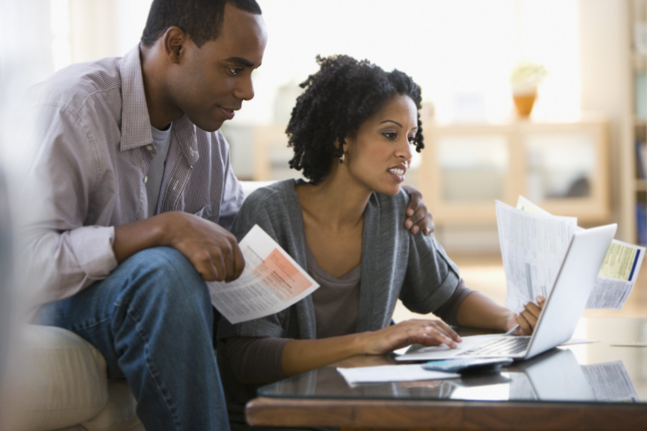 Couple looking over finances on laptop