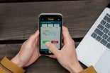 Person using mobile trading app to buy and sell stocks