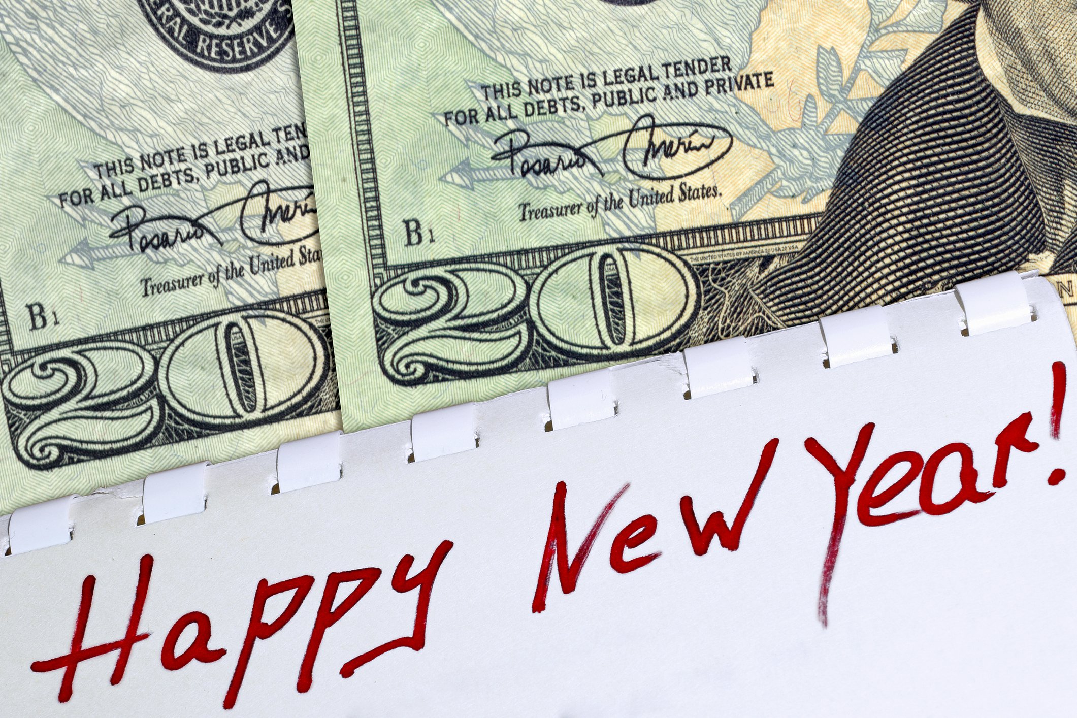 Two twenty dollar bills laid out to represent the year 2020, with the words, Happy New Year, written underneath.
