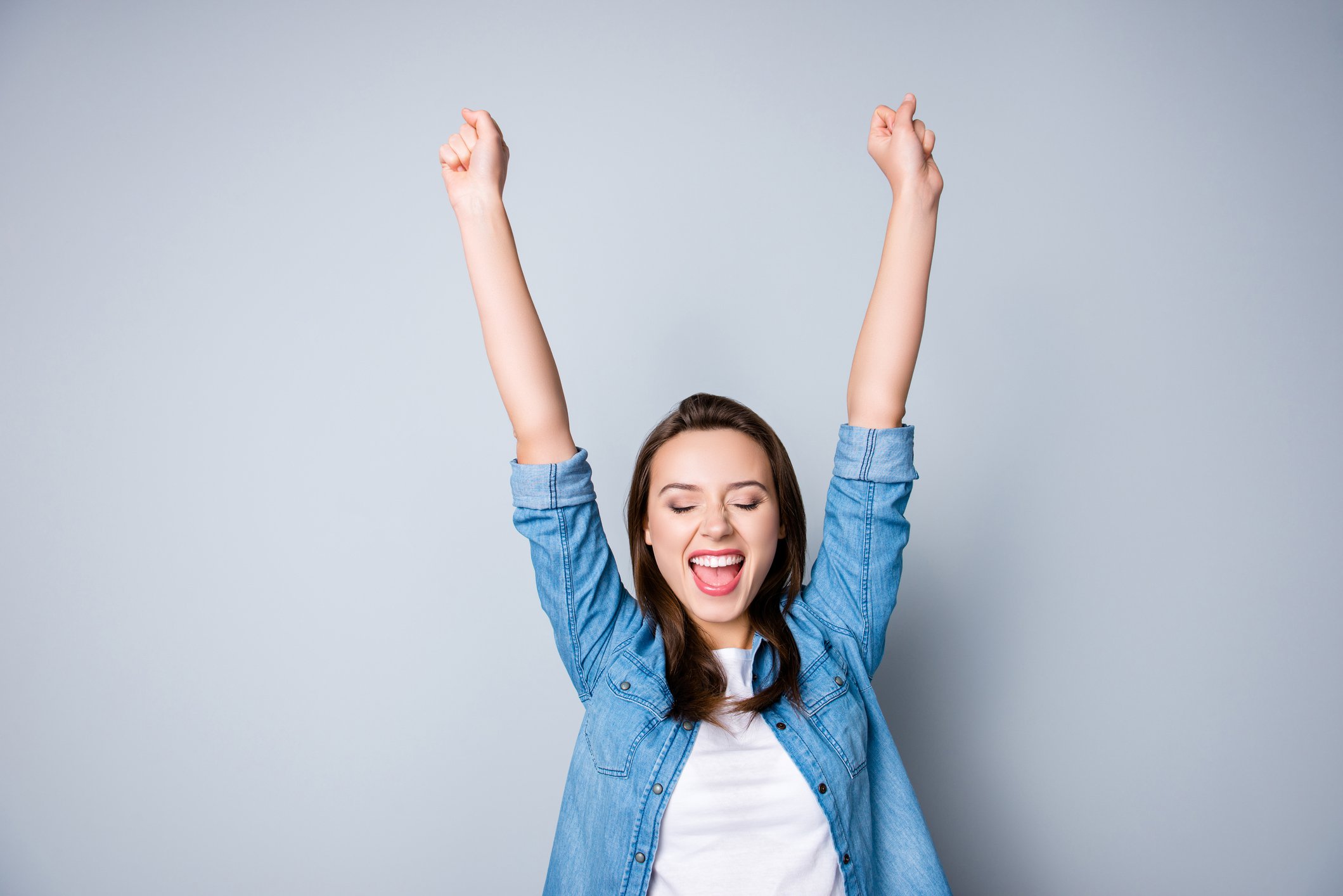 Happy young woman with arms up