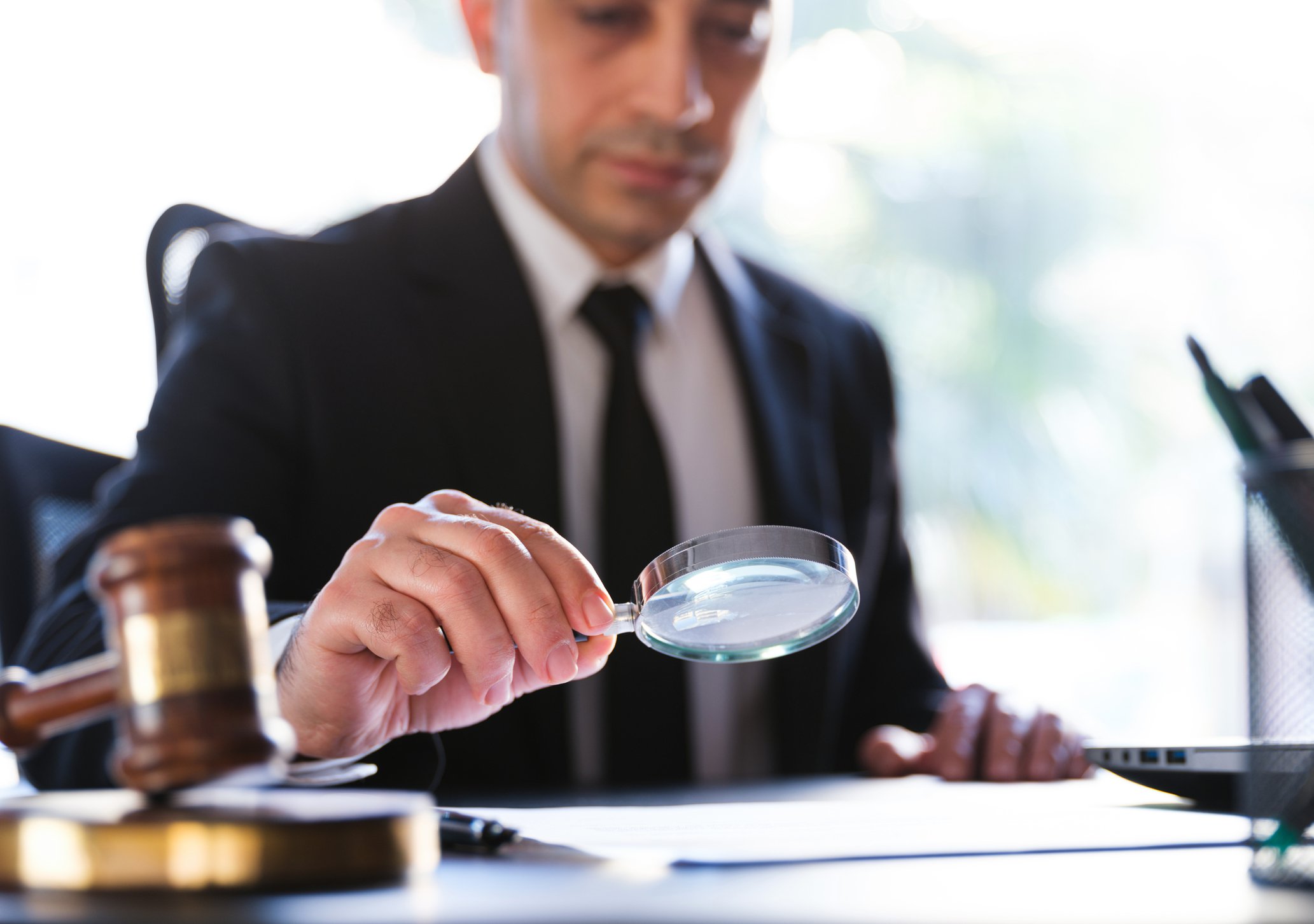 Man looking through a magnifying glass.