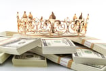 Golden crown resting on piles of cash