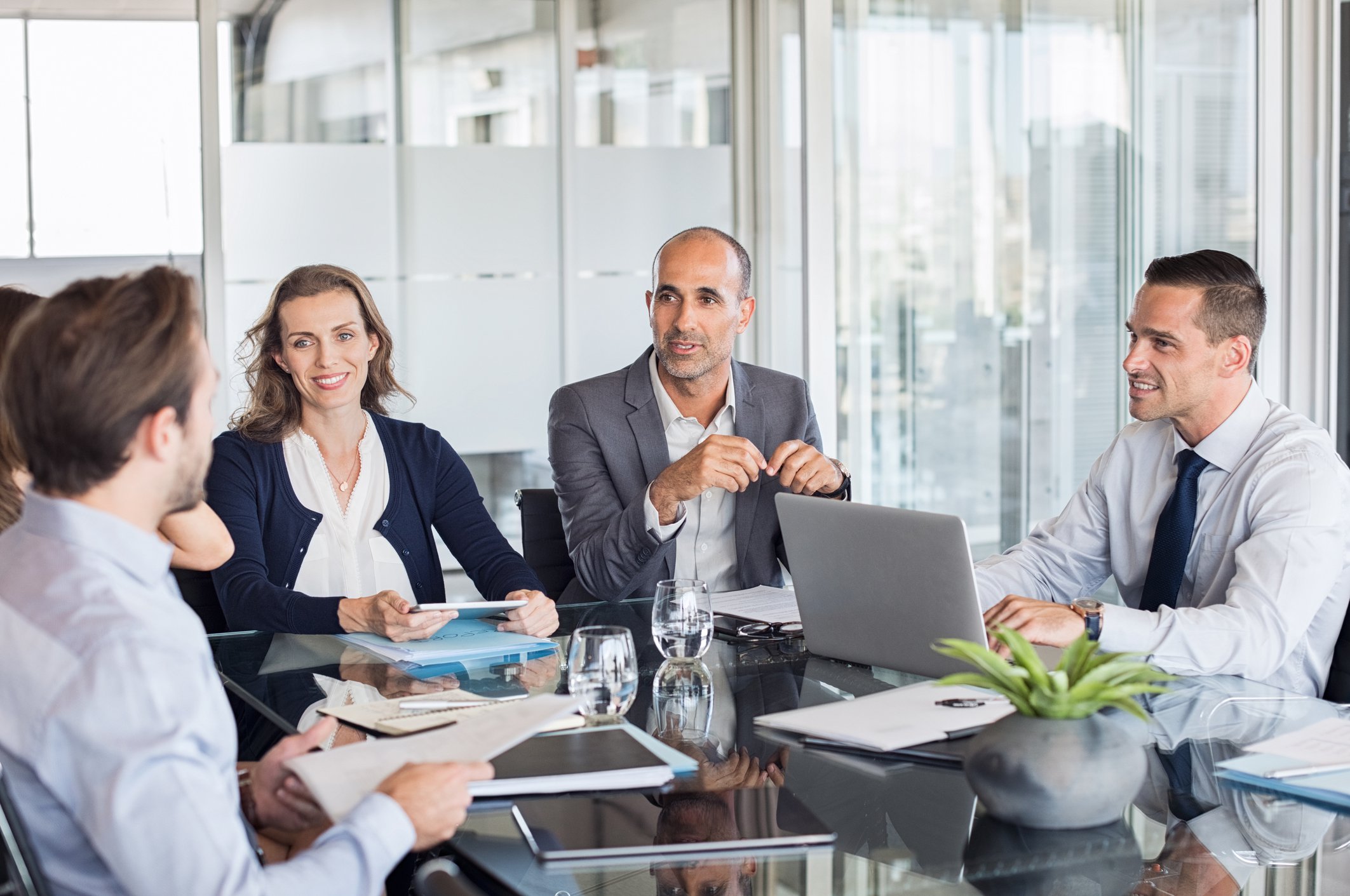 A group of professionals around a table at a meeting.