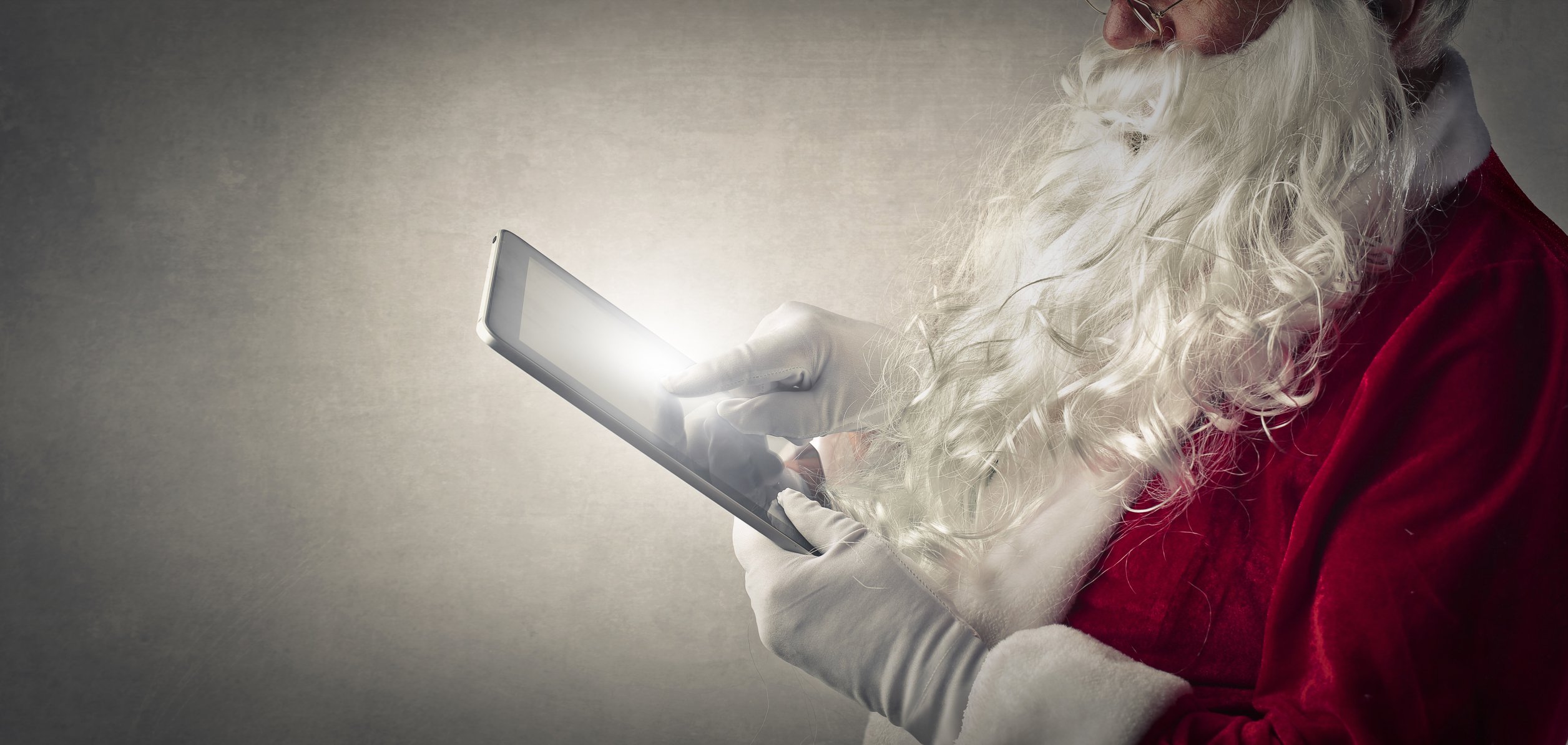 man in Santa suit using a tablet -- Christmas present gift iPad technology