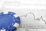 A blue poker chip atop a graph.
