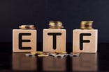 Blocks with the letters E, T, and F on them with gold and silver coins around them.