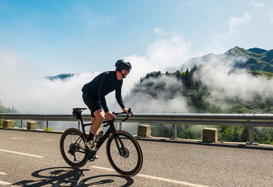 Someone on a highway riding a bike overlooking a mountain.