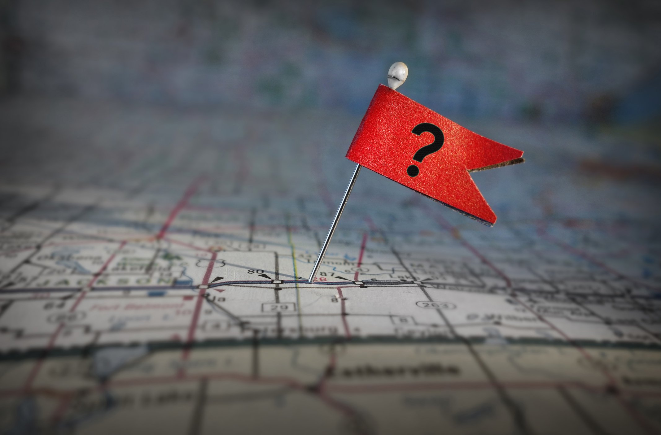 A question mark flag pinned on a map.