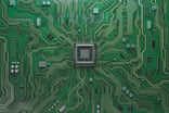 A semiconductor chip on green board.