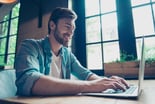 Smiling man typing on laptop
