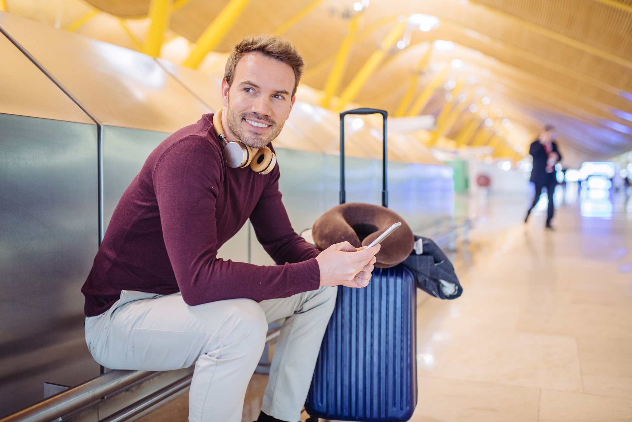 Smiling man with suitcase at airport