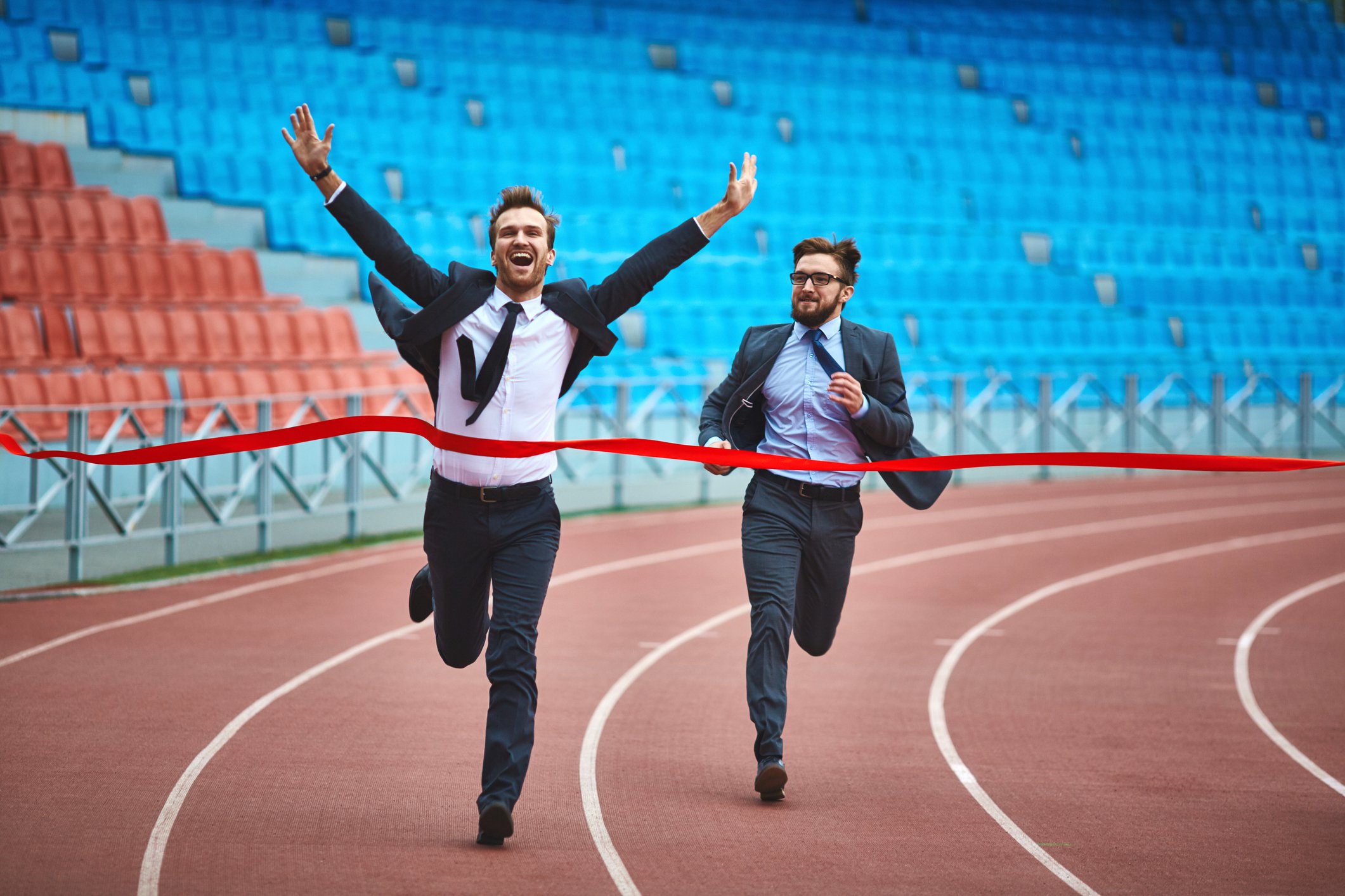 two businessmen cross a finish line