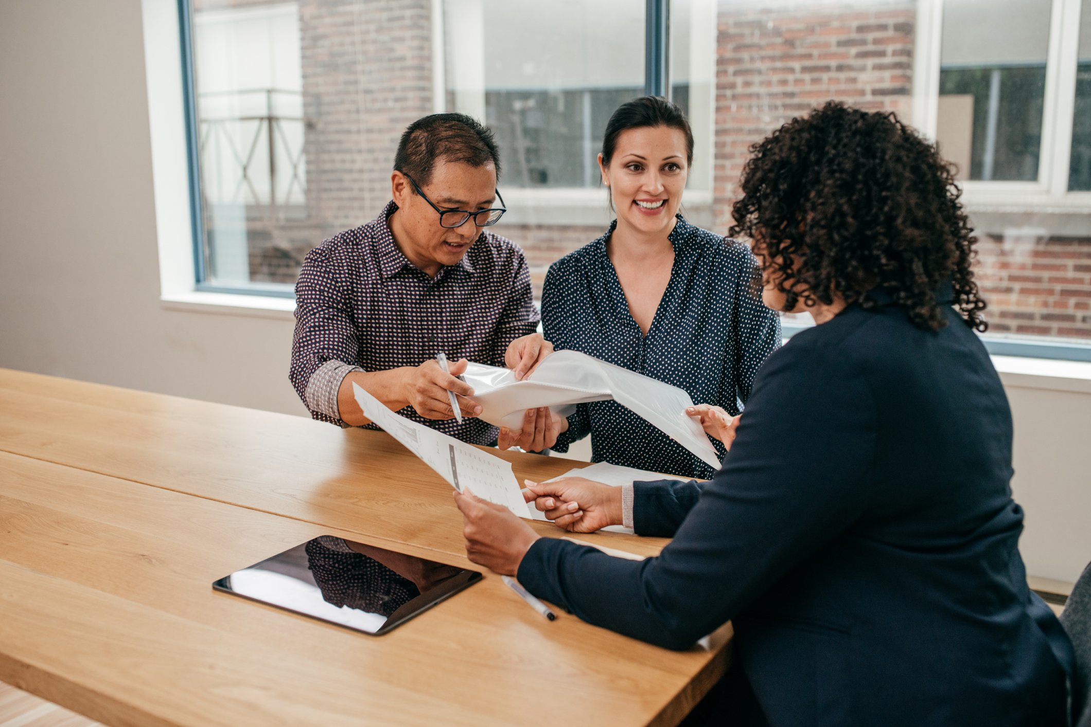 Three people reviewing documents
