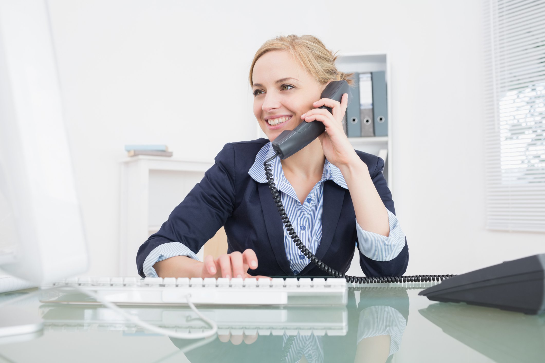 Woman at desk talking on the phone.