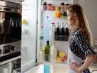 Woman looking inside her refrigerator.