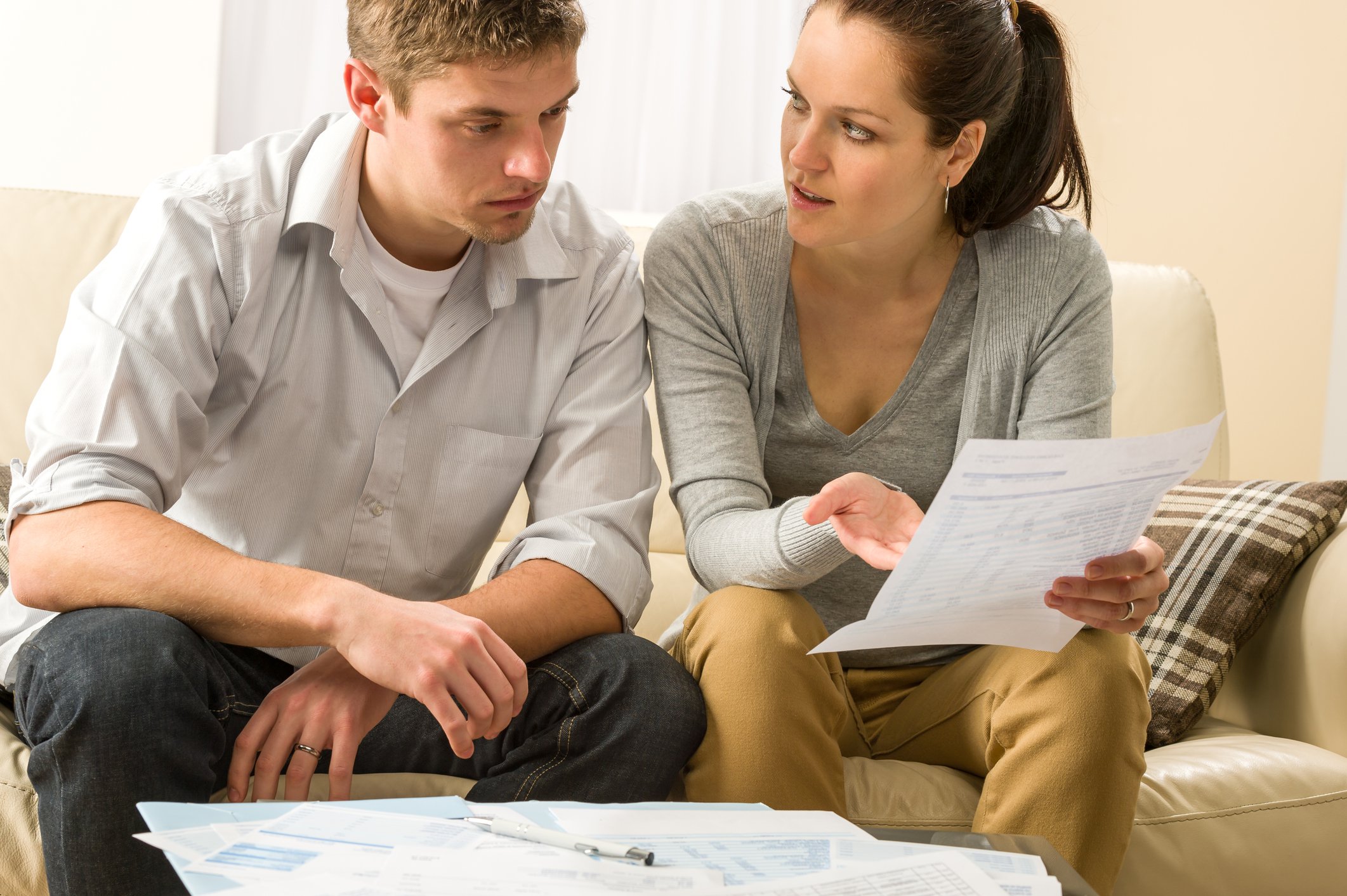 Young couple discussing financial documents and looking worried