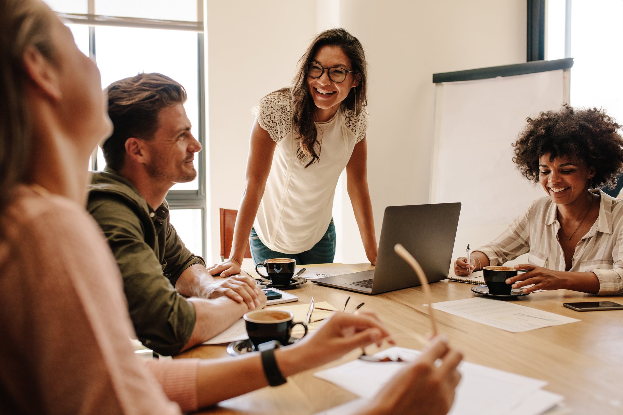 Young professionals at a table smiling.