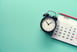 Alarm clock next to calendar