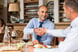 Two professional men shaking hands over a meal.