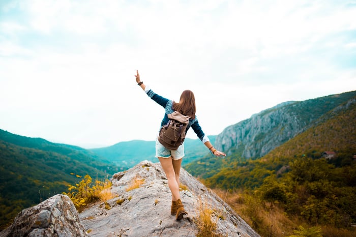 Someone is hiking on a steep ridge, with arms out for balance.