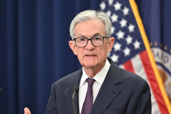 Jerome Powell from the shoulders up with an American flag behind him.